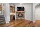 Cozy living area featuring a stone fireplace, built-in tv, wine fridge and access to a stairway at 4364 Chateau Ridge Ln, Castle Rock, CO 80108