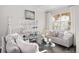 Cozy living room with plush seating, decorative shelving and a large window providing natural light at 1004 Roslyn Ct, Denver, CO 80230