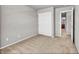 Neutral bedroom featuring carpet floors, a closet with sliding doors, and an attached bathroom at 17359 Waterhouse Cir # C, Parker, CO 80134