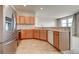 Bright kitchen features stainless steel appliances and wood cabinets with tile flooring at 17359 Waterhouse Cir # C, Parker, CO 80134