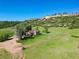 Idyllic aerial view of home featuring a welcoming deck nestled in a lush green landscape, with a scenic bluff in the background at 1151 Castlewood Pl, Franktown, CO 80116