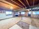 Unfinished basement with exposed wooden beams, brick fireplace, and windows at 1151 Castlewood Pl, Franktown, CO 80116