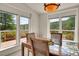Light filled dining room with glass table and views of trees and foliage at 153 Gold Run Trl, Idaho Springs, CO 80452