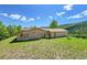 Back exterior view showing a charming home and its green backyard at 153 Gold Run Trl, Idaho Springs, CO 80452