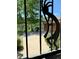 View through a decorative security gate shows a patio set and view of the surrounding greenery at 153 Gold Run Trl, Idaho Springs, CO 80452