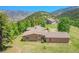 An expansive home nestled amidst lush greenery, featuring a well-maintained lawn and a sprawling roofline at 153 Gold Run Trl, Idaho Springs, CO 80452