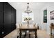 Bright dining room with a wooden table, patterned chairs, and a stylish chandelier, set against a black accent wall at 1803 S Coolidge St, Aurora, CO 80018