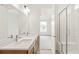 Modern bathroom featuring double sinks, white quartz countertops, and a glass enclosed shower at 20590 E 58Th Ave, Aurora, CO 80019