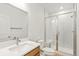 Bathroom offers a double vanity with quartz countertop, glass shower, and stylish finishes at 20590 E 58Th Ave, Aurora, CO 80019
