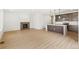 Open-concept living room with a fireplace and a modern kitchen island at 20590 E 58Th Ave, Aurora, CO 80019