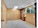 View of the basement featuring wood paneling, built in shelving, and a window at 7448 W Geddes Pl, Littleton, CO 80128