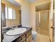 Bathroom featuring a shower with glass doors, large mirror, and light-colored walls at 7448 W Geddes Pl, Littleton, CO 80128
