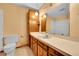Vintage bathroom with a blue sink, wood cabinets, and a large mirror above the countertop at 7448 W Geddes Pl, Littleton, CO 80128