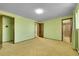 Bedroom featuring green walls, three doorways, and neutral carpeted floors at 7448 W Geddes Pl, Littleton, CO 80128