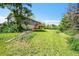 Backyard showcasing a well-maintained lawn, mature trees, and the home's exterior with a deck at 7448 W Geddes Pl, Littleton, CO 80128