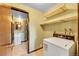 Laundry room with shelving, a modern washing machine, and access to a small sink in the next room at 7448 W Geddes Pl, Littleton, CO 80128