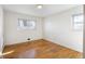 Bedroom featuring light hardwood floors, two windows, and neutral white walls at 35 S Cody St, Lakewood, CO 80226