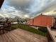 Overlooking deck area and backyard space with neighboring garages and cloudy sky above at 6921 S Bryant St, Littleton, CO 80120