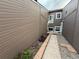 Exterior side view with narrow walkway, brown siding and brick details at 6921 S Bryant St, Littleton, CO 80120