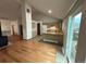 Open concept living room featuring hardwood floors, fireplace, and view into kitchen at 6921 S Bryant St, Littleton, CO 80120