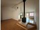 Open-concept living room with hardwood floors and wood burning stove at 6921 S Bryant St, Littleton, CO 80120