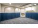 Spacious basement featuring custom blue wainscoting, neutral walls, gray carpet, and archway details at 2445 W 39Th Ave, Denver, CO 80211
