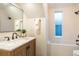 Bathroom with a sleek, modern design with a shower and tub combination, a window, and tile at 2445 W 39Th Ave, Denver, CO 80211