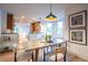 Open dining area with wood table set, updated lighting fixture, art, and access to an updated kitchen at 2445 W 39Th Ave, Denver, CO 80211