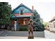 Charming red brick home with a bear statue in front and a real estate sign in the yard at 2445 W 39Th Ave, Denver, CO 80211