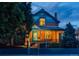 Charming two-story brick home with a covered front porch, black iron fence and inviting curb appeal at twilight at 2445 W 39Th Ave, Denver, CO 80211