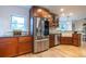 Kitchen featuring stainless steel refrigerator, wood cabinetry, updated sink, and hardwood floors at 2445 W 39Th Ave, Denver, CO 80211
