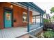 Inviting front porch with blue trim, brick facade, a wooden swing, and a blue front door at 2445 W 39Th Ave, Denver, CO 80211
