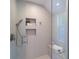 Modern shower featuring gray tile, built-in shelving, glass enclosure, and sleek fixtures at 2445 W 39Th Ave, Denver, CO 80211