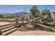 Well-maintained backyard featuring a garden area, brick steps, bench, and mature trees at 9435 Winding Hill Way, Lone Tree, CO 80124