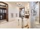 Elegant bathroom featuring a soaking tub, walk-in closet, chandelier, and custom tile work in the shower at 9435 Winding Hill Way, Lone Tree, CO 80124