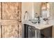 Elegant powder bathroom with marble countertop, vessel sink, and decorative wood door at 9435 Winding Hill Way, Lone Tree, CO 80124