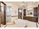 Luxurious bathroom featuring a soaking tub, chandelier, walk-in closet, and glass shower at 9435 Winding Hill Way, Lone Tree, CO 80124