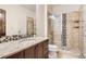 Modern bathroom with granite countertop, glass shower, and neutral tile at 9435 Winding Hill Way, Lone Tree, CO 80124