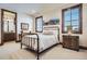 Comfortable bedroom with wood trim, a black metal bedframe, and natural light at 9435 Winding Hill Way, Lone Tree, CO 80124
