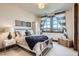 Serene bedroom with metal frame bed, striped curtains framing outdoor view, and ample natural light at 9435 Winding Hill Way, Lone Tree, CO 80124