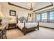 Bright bedroom featuring a wrought iron bed frame, wood trim, and multiple windows for natural light at 9435 Winding Hill Way, Lone Tree, CO 80124