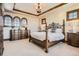 Cozy bedroom with a decorative tray ceiling, chandelier, and a wrought iron bed frame at 9435 Winding Hill Way, Lone Tree, CO 80124