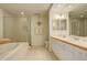 Bathroom with a soaking tub, a glass-enclosed shower, and double sink vanity at 300 Hudson St # 202, Denver, CO 80220