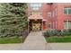 Inviting building entrance with well-maintained landscaping and red brick facade at 300 Hudson St # 202, Denver, CO 80220