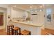 Bright kitchen with white cabinetry, counter seating, and modern appliances at 300 Hudson St # 202, Denver, CO 80220