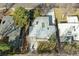 Aerial view of a backyard featuring a stone patio and green lawn surrounded by mature trees at 1486 S Elm St, Denver, CO 80222