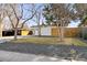 Well-maintained mid-century modern home with a xeriscaped front yard and white privacy fence at 1486 S Elm St, Denver, CO 80222