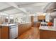 Modern kitchen featuring stainless steel appliances, an island with bar seating, and wood cabinetry, creating an inviting culinary space at 1486 S Elm St, Denver, CO 80222