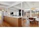 Open concept kitchen with sleek countertops, light wood cabinets, and stainless steel appliances seamlessly integrated with the dining area at 1486 S Elm St, Denver, CO 80222