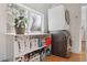 Bright laundry area with stacked washer/dryer unit, storage shelves, and natural light from the window at 1486 S Elm St, Denver, CO 80222